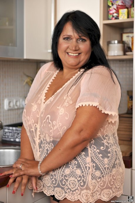 BBW brunette Bubi poses and displays her big natural tits in a kitchen