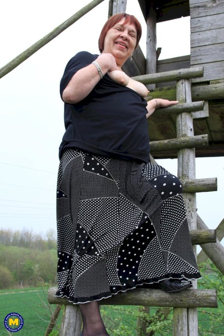 Redhead granny Sheila reveals her swollen vagina on an outdoor ladder
