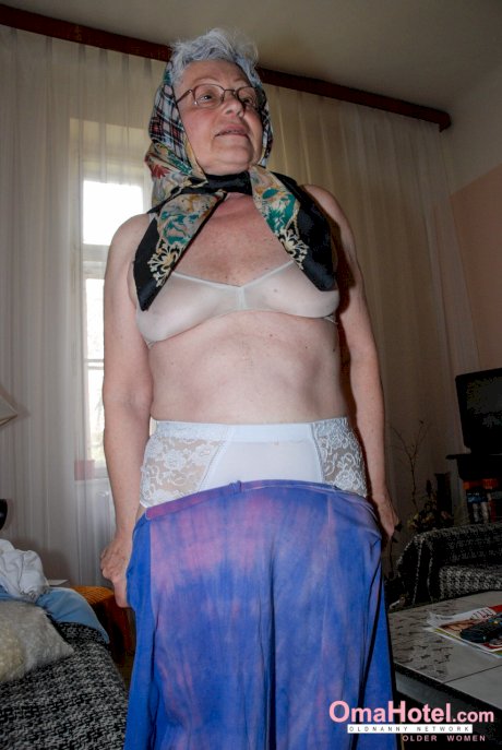 Cute granny with glasses Agnes strips and massages a nice fat dick