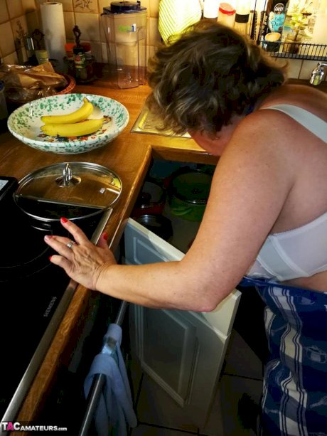 Old housewife Caro takes off her underwear in kitchen apron and stockings
