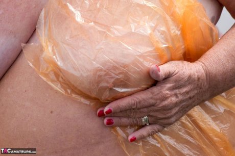 Obese oma Grandma Libby doffs a see-through raincoat to get naked on a bridge