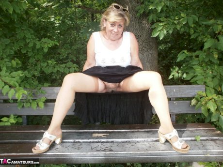 Mature amateur whore Caro masturbating on the bench in the woods