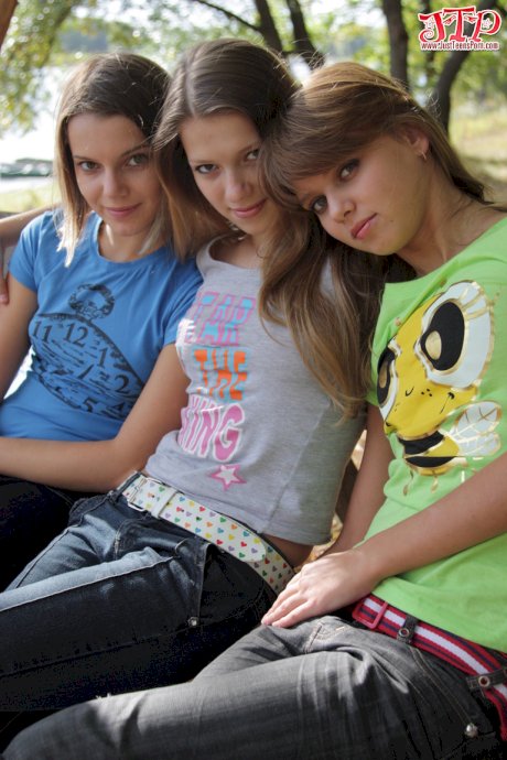 3 young girls remove T-shirts and jeans to model naked on park bench