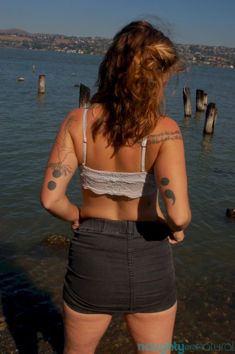 Saucy young slut Lilah strips by the water and unveils her hairy body