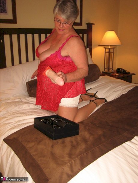 Fat granny Girdle Goddess whips out her big boobs on a bed in pantyhose