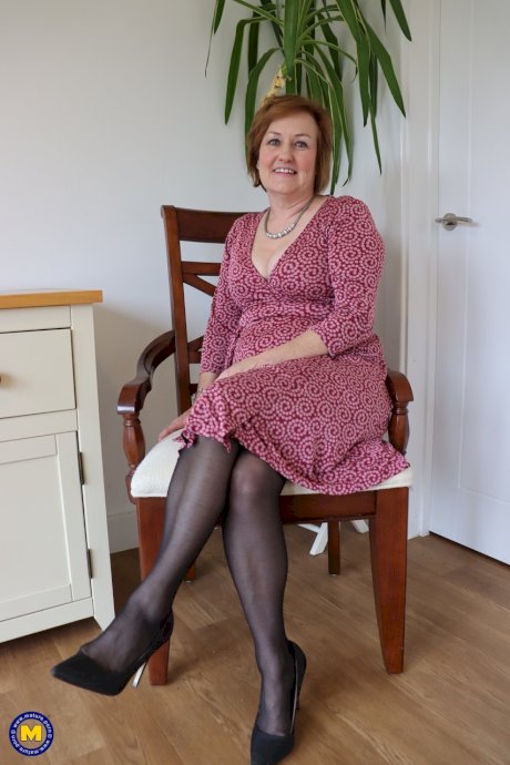 Mature redhead masturbates with a sex toy in garters and nylons