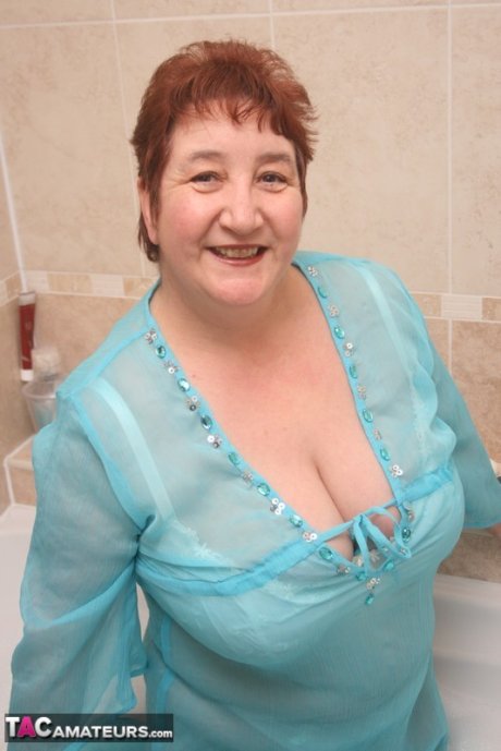 Redhead nan Kinky Carol parks her fat figure in a tub while fully clothed