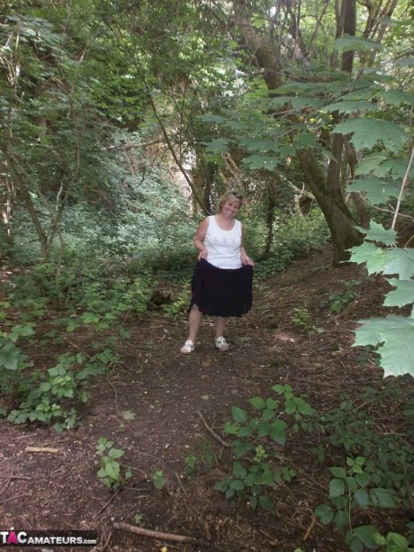 Mature amateur whore Caro masturbating on the bench in the woods
