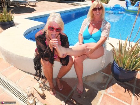Mature blonde fatty Melody and her lesbian lover have foot play near a pool