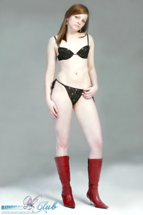 Pale redhead Lilly slowly strips to a black G-string and red leather boots