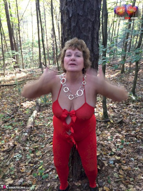 Older lady Busty Bliss gets completely naked while in a forest