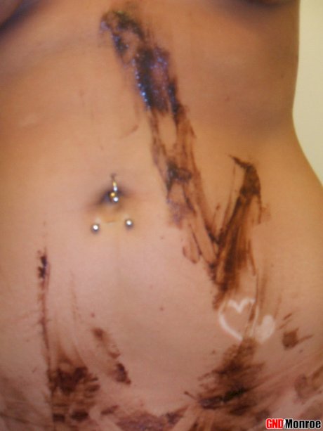 Blonde girl with striking eyes covers her naked body in chocolate sauce