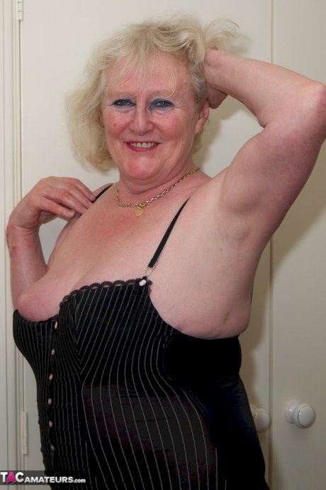 Blonde granny Claire Knight finger fucks her bald pussy in stockings on a bed