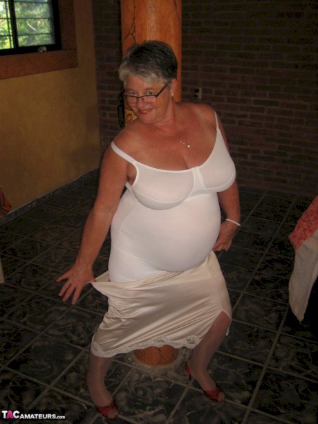 Fat granny Girdle Goddess holds her saggy tits in her hands by a pillar