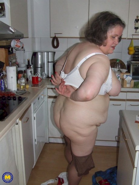 Fat mature housewife Birgid masturbates with a cucumber in the kitchen