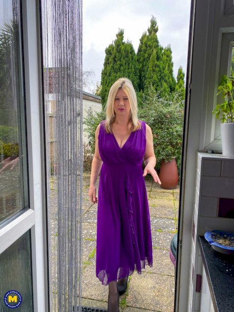 Mature blonde Laura Chalice doffs a long dress before fondling her tits & twat