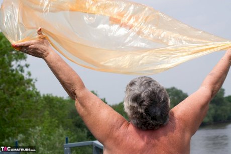 Obese oma Grandma Libby doffs a see-through raincoat to get naked on a bridge