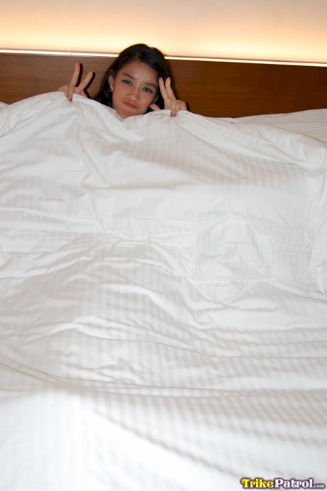 Amateur Asian girl Alexis reveals her petite figure and poses on a bed
