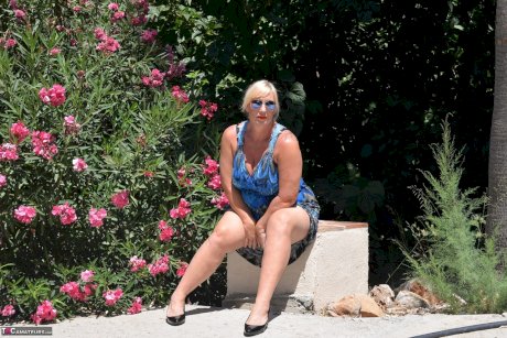 Mature blonde fatty Melody takes off her dress to pose in her underthings