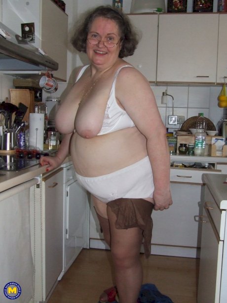 Fat mature housewife Birgid masturbates with a cucumber in the kitchen