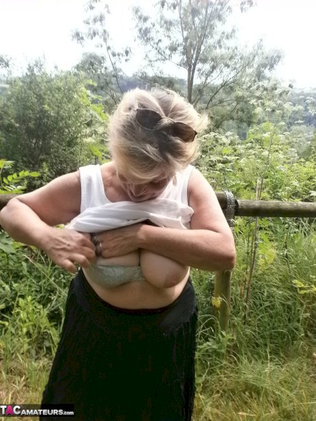Mature amateur whore Caro masturbating on the bench in the woods