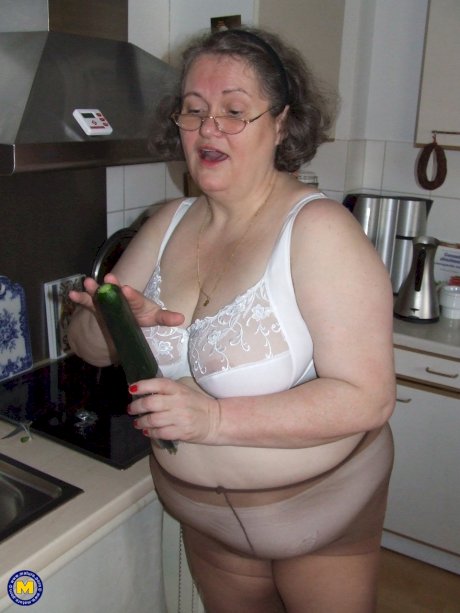 Fat mature housewife Birgid masturbates with a cucumber in the kitchen