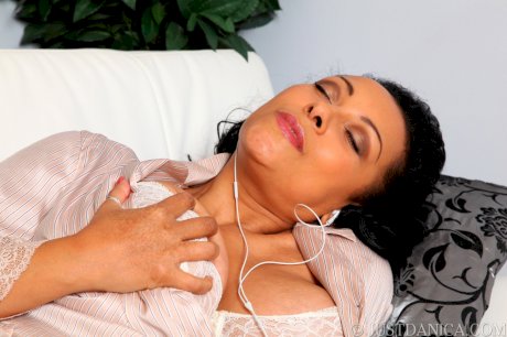 Mature woman Danica Collins masturbates her moist pussy in her pajamas