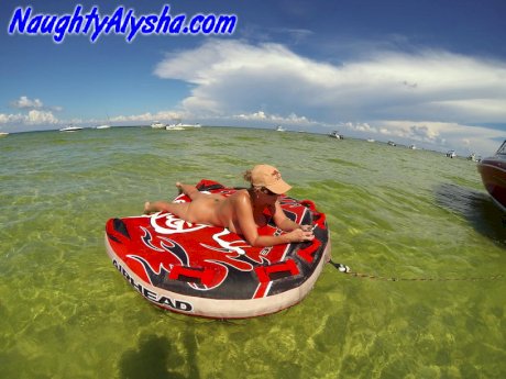 Big titted amateur lounges on an air mattress while naked in a ball cap