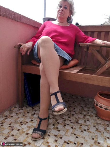 Horny oma spreads her upskirt pussy after pulling down her hose on patio