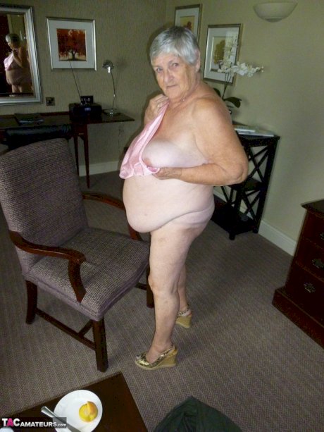 Obese grandmother licks her own nipples as she strips naked in living room