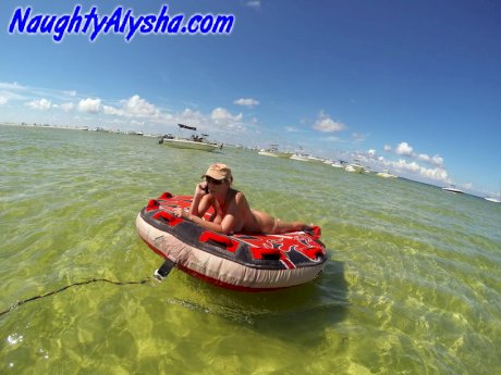 Big titted amateur lounges on an air mattress while naked in a ball cap