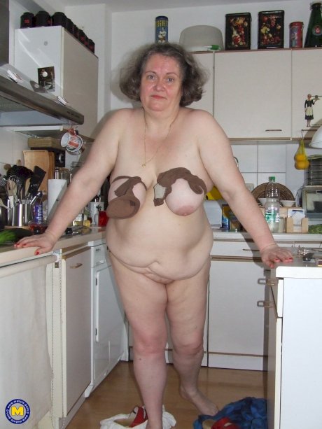 Fat mature housewife Birgid masturbates with a cucumber in the kitchen