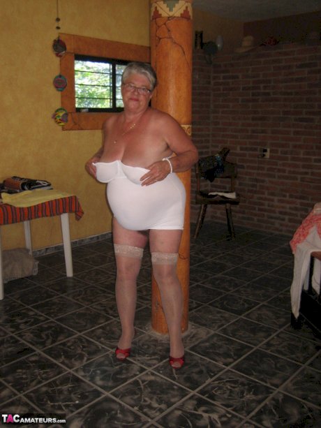 Fat granny Girdle Goddess holds her saggy tits in her hands by a pillar