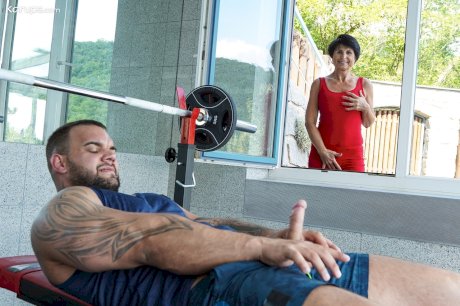 Lusty granny Petra T gets fucked by a muscular tattooed dude at the gym