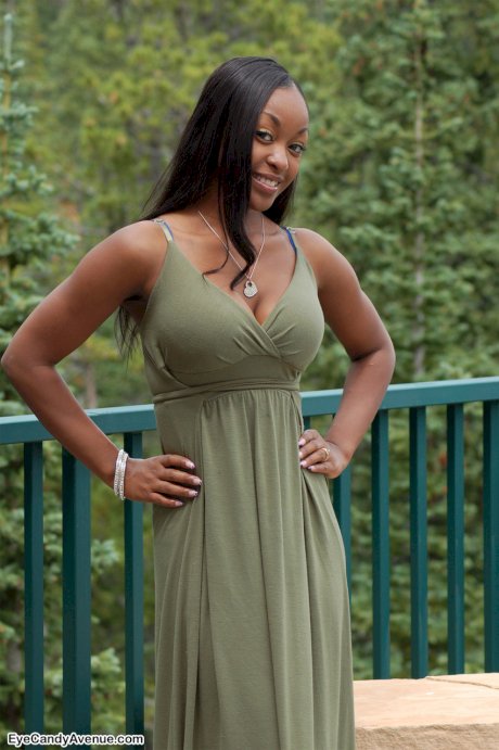 Ebony amateur Amber releases her big tits from a long dress on a balcony