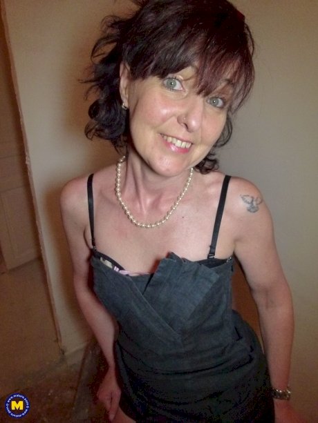 Mature brunette Joyce Mifle strips her clothes & poses in her lingerie