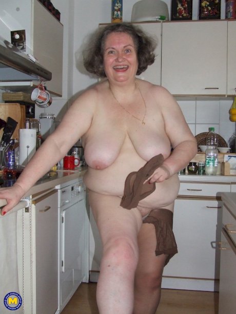 Fat mature housewife Birgid masturbates with a cucumber in the kitchen