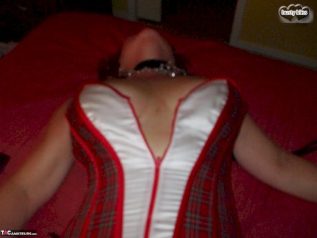 Mature lady Busty Bliss sports nipple clamps after being handcuffed