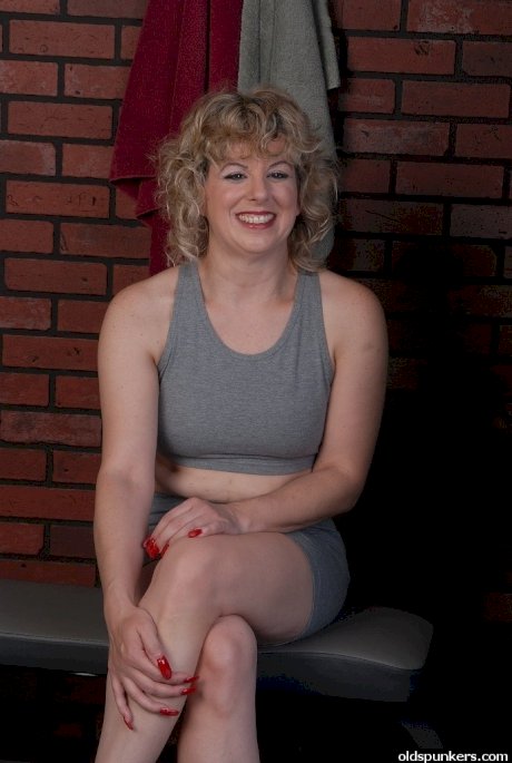 Fit mature woman masturbates inside the fitness center locker room