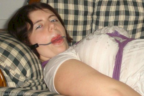 Overweight girl has her hands tied behind her back while her ankles are bound