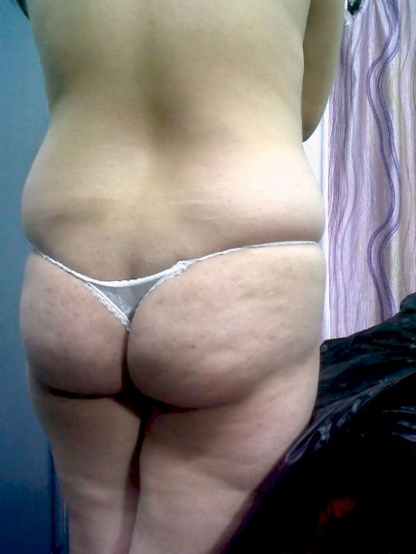 Fat Indian woman hides her face while adorned in a bra and thong