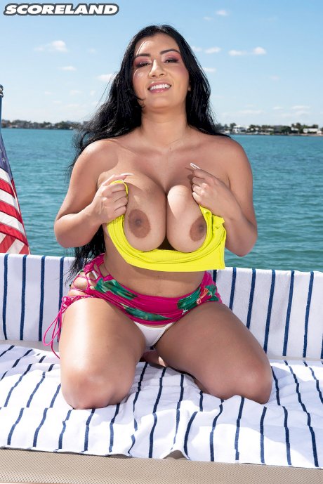 Dark-haired Latina female Selena Adams bares her large boobs on a boat