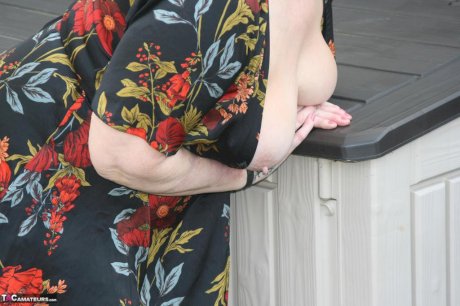 Naughty granny shows her tits and twat in backyard wearing red stockings