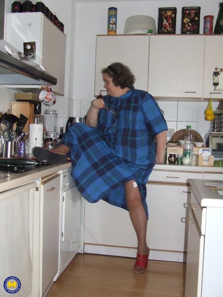 Fat mature housewife Birgid masturbates with a cucumber in the kitchen