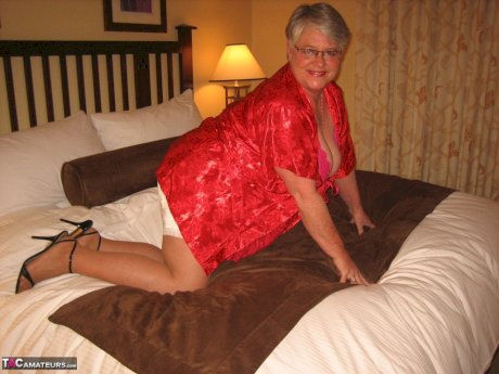 Fat granny Girdle Goddess whips out her big boobs on a bed in pantyhose