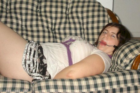 Overweight girl has her hands tied behind her back while her ankles are bound