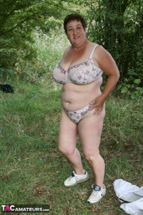 Mature BBW Kinky Carol strips to her lingerie in a wooded setting