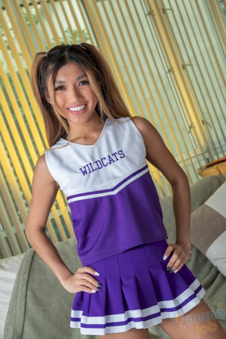 Asian cheerleader Clara Trinity discards her uniform before riding a cock