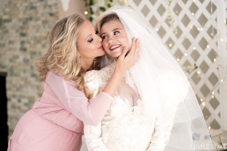 Carolina Sweets is affixed with a garter before a lesbian wedding to Julia Ann