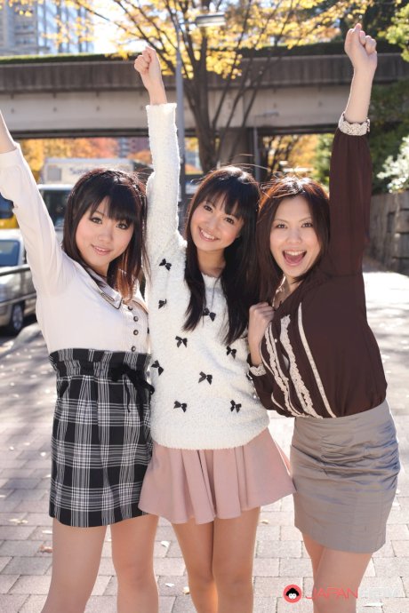 Three Japanese girls in skirts pose outdoors for a SFW shoot